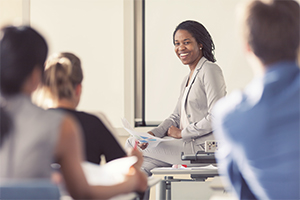 A female professor teaching college aged students in a classroom